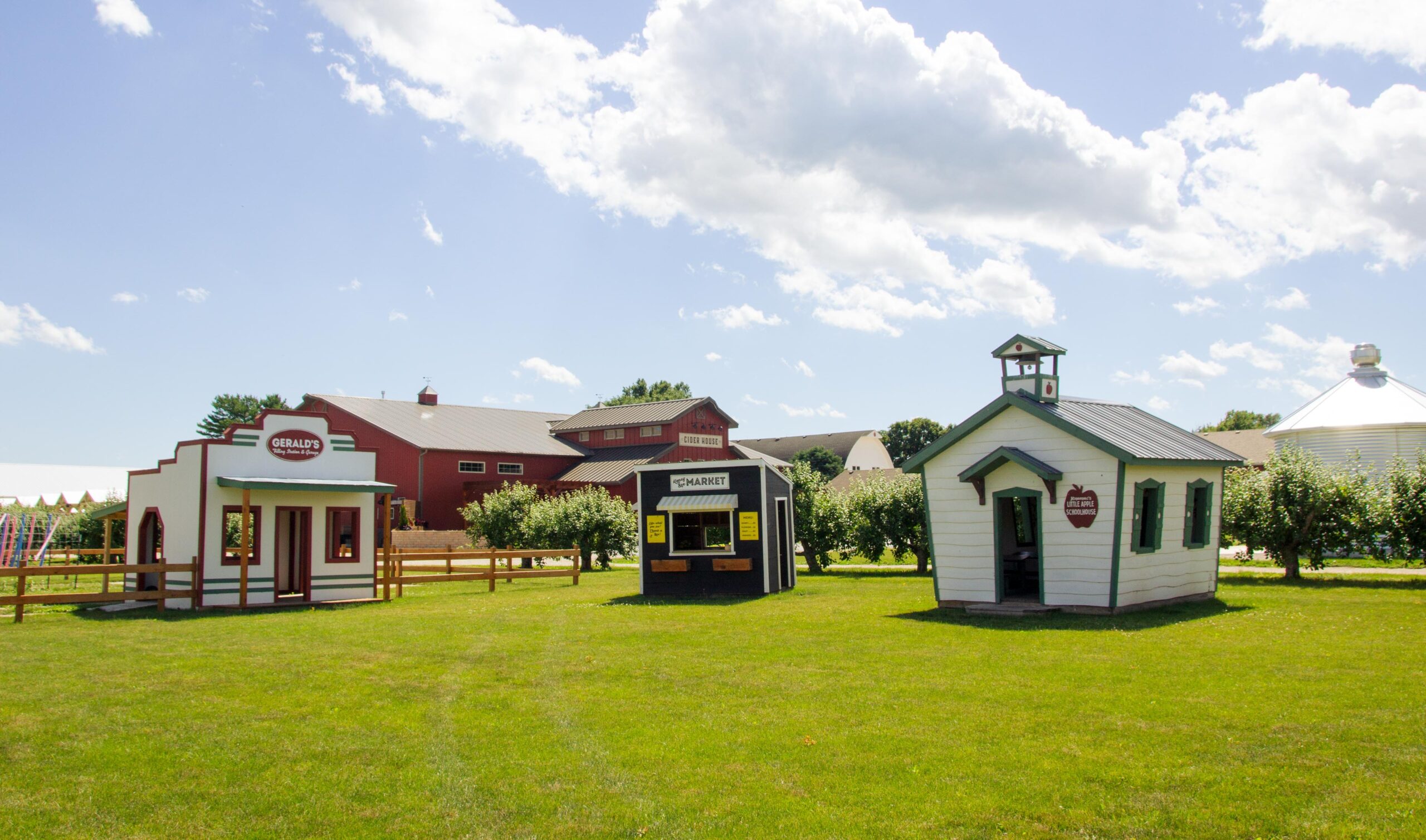 Small shops on grassy field under clear sky.