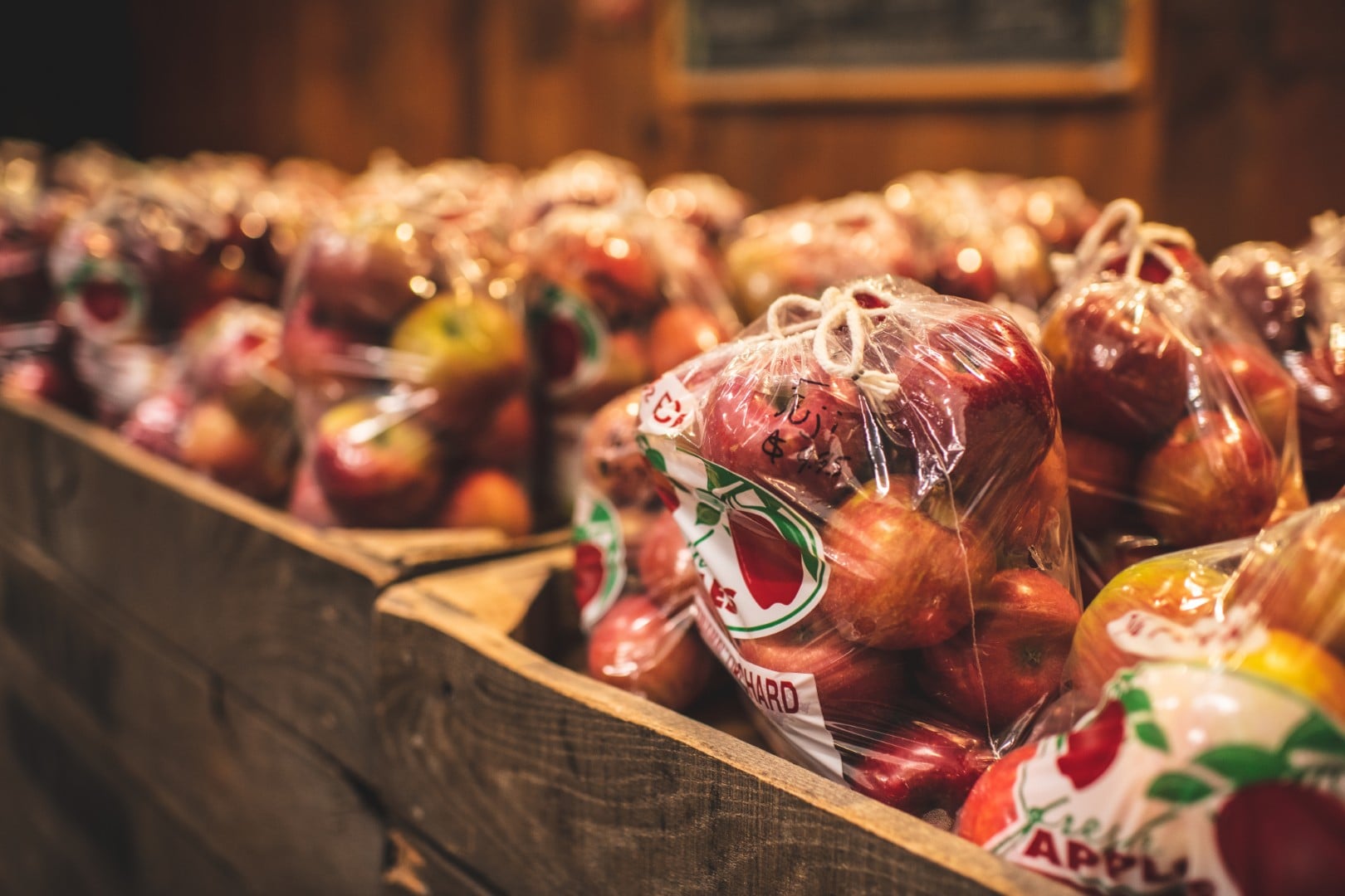 Bags of fresh apples in wooden crates.