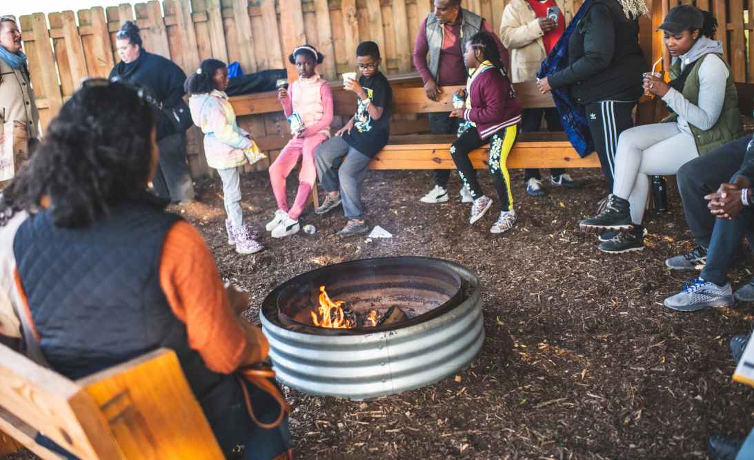 People sitting around a cozy outdoor fire pit.