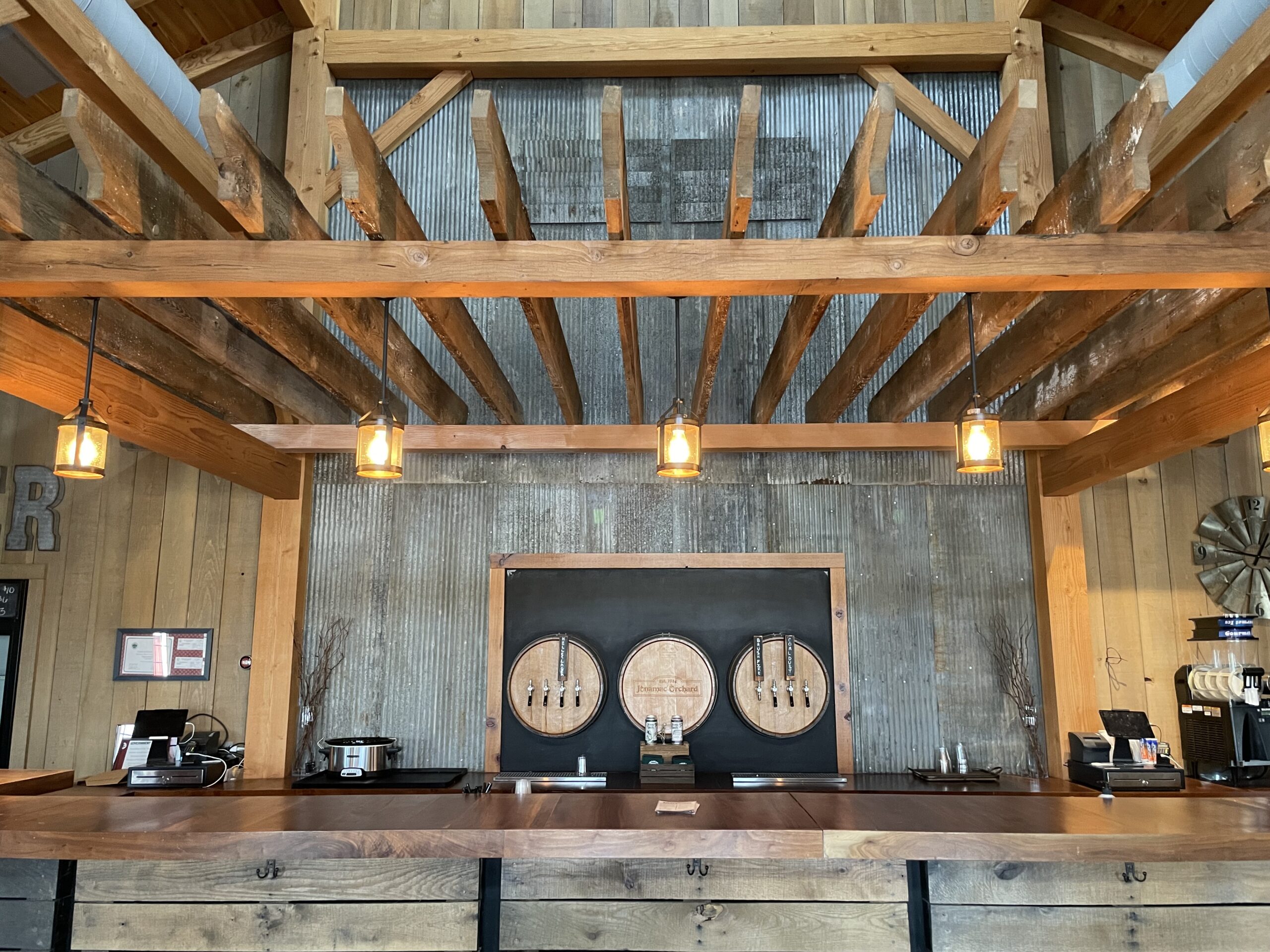Rustic brewery interior with wooden beams and bar counter.