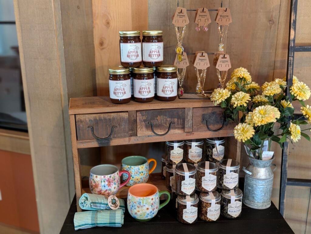 Rustic display with apple butter and floral mugs.