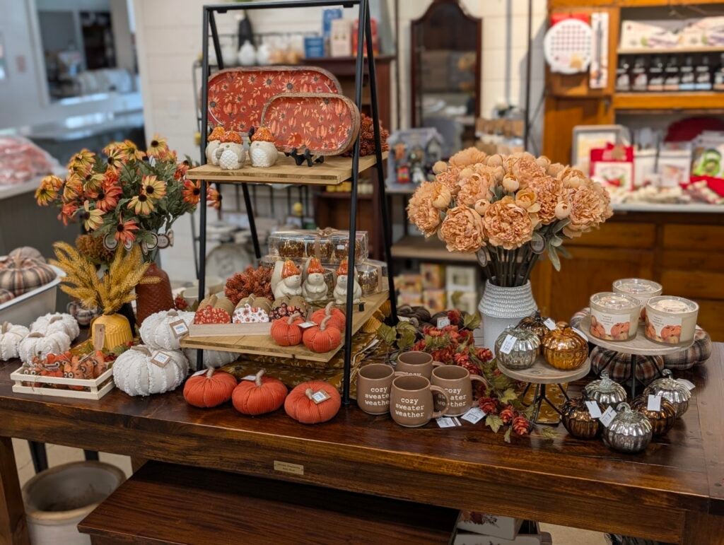 Autumn-themed home decor display with pumpkins and flowers.