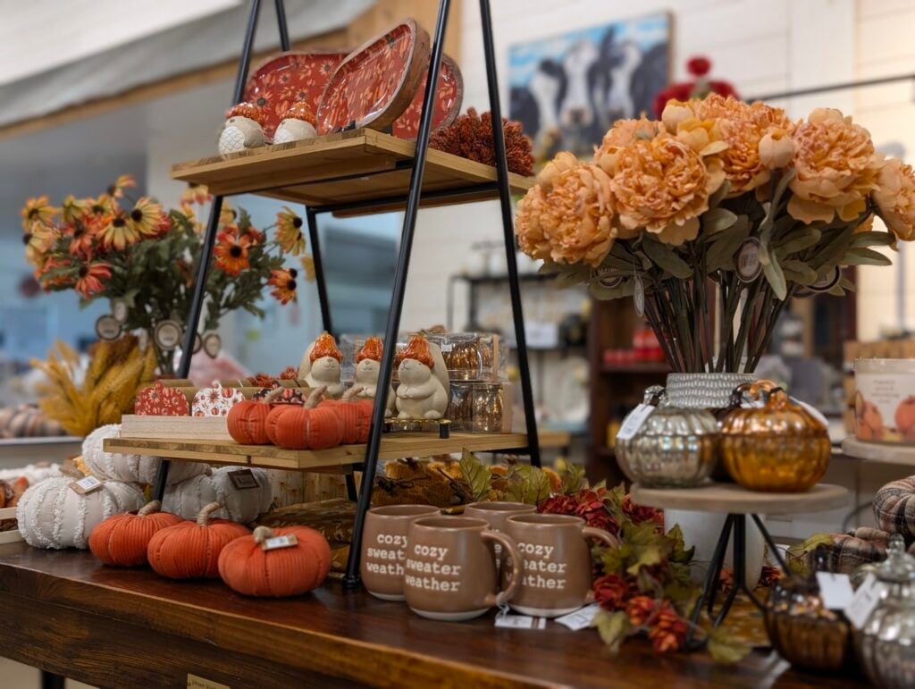 Autumn-themed table display with pumpkins and flowers.