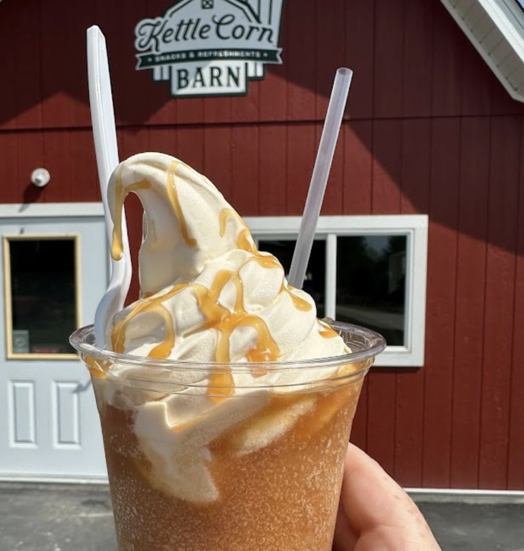 Caramel soft serve milkshake in front of red barn.