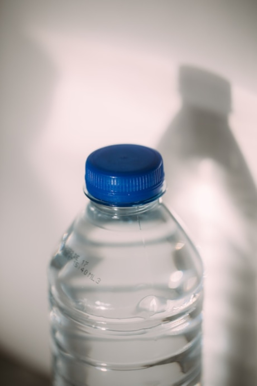 Plastic water bottle with blue cap.