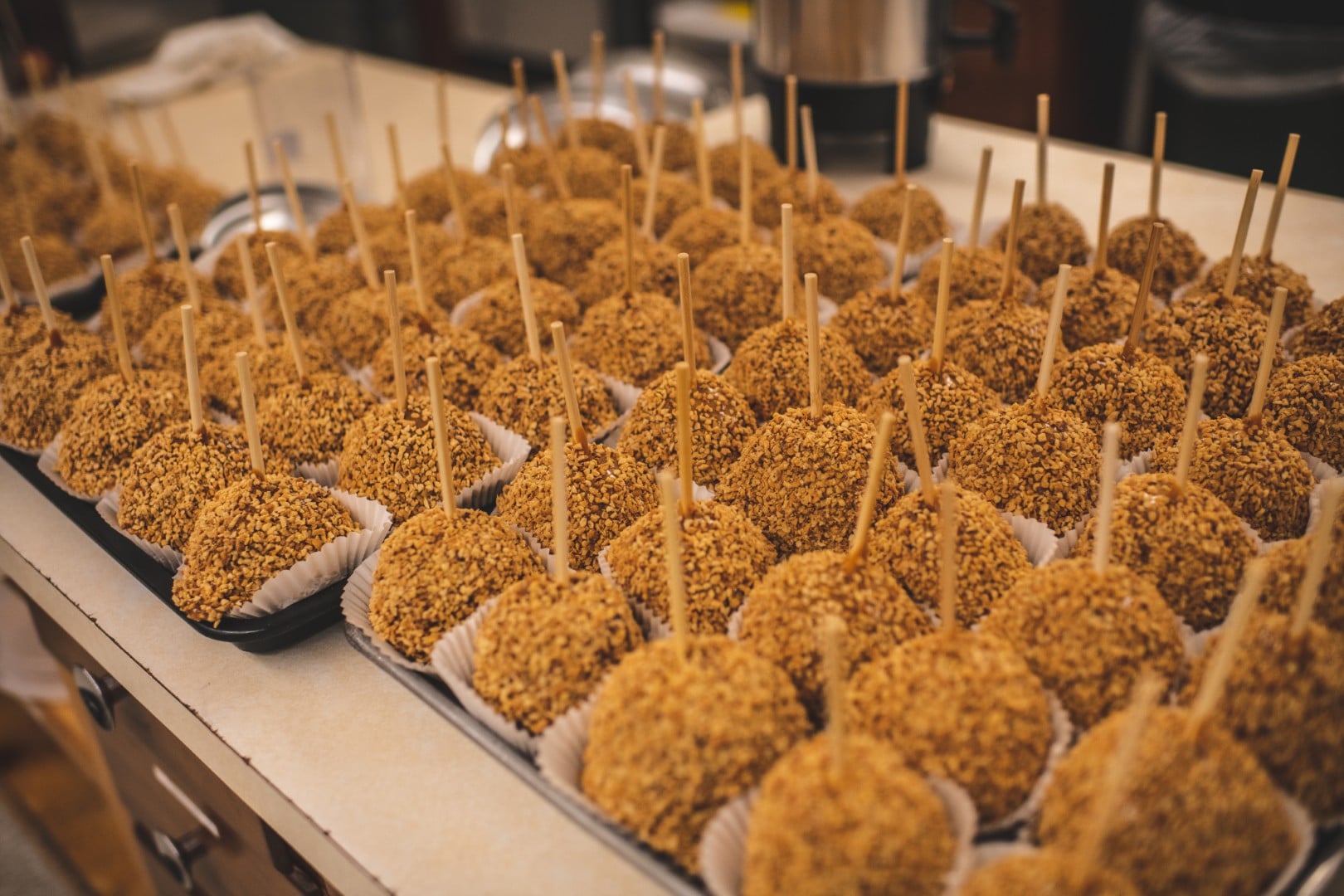 Caramel apples with nut coating on display.