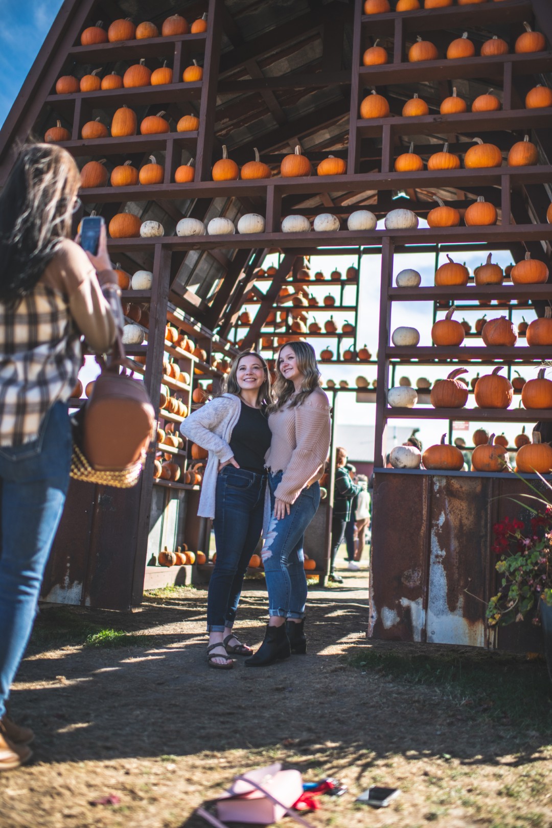 People posing at pumpkin patch display, photographed.