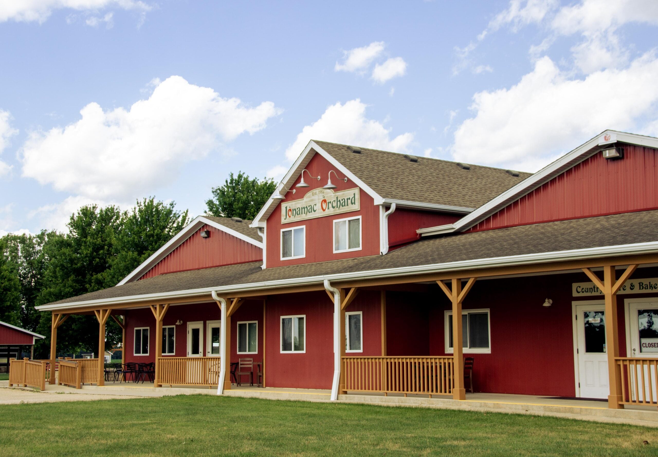 Red apple orchard building under blue sky.